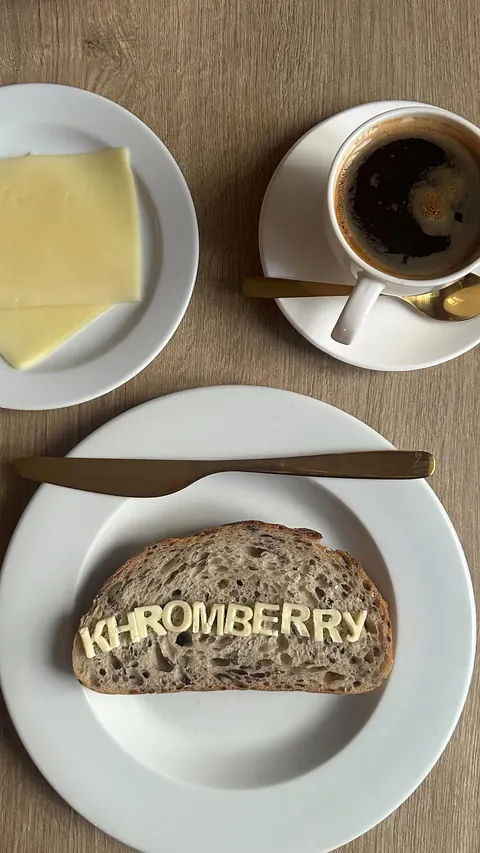 Breakfast at Khromberry: sourdough toast with butter letters spelling KHROMBERRY, coffee with gold cutlery